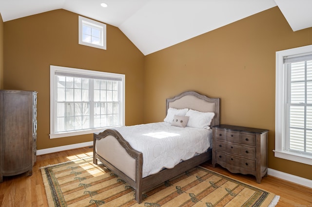 bedroom featuring baseboards, multiple windows, wood finished floors, and vaulted ceiling