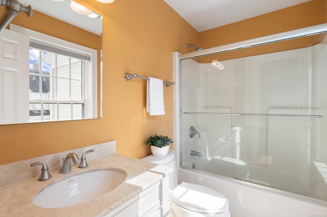 full bath featuring toilet, vanity, and shower / bath combination with glass door