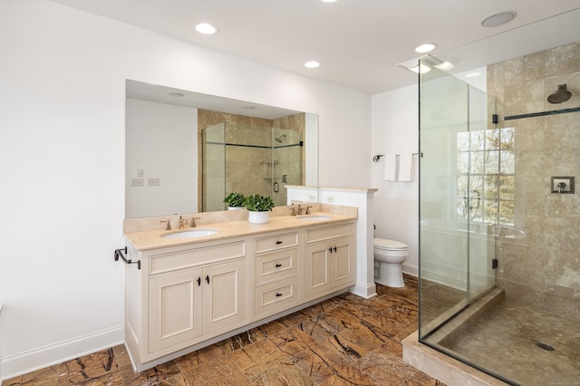 bathroom featuring double vanity, a shower stall, baseboards, and a sink