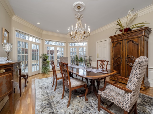 dining space with light wood-style floors, recessed lighting, a notable chandelier, and crown molding