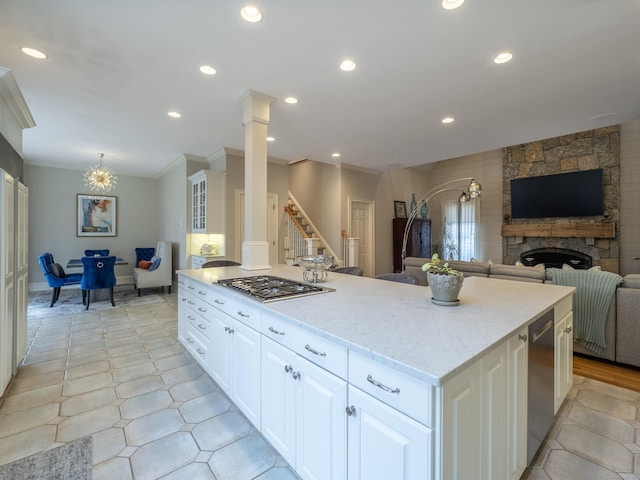 kitchen with recessed lighting, a fireplace, open floor plan, appliances with stainless steel finishes, and ornamental molding