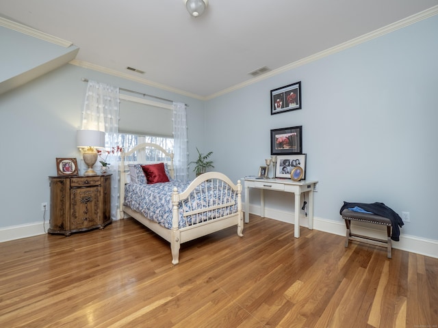 bedroom with baseboards, ornamental molding, visible vents, and light wood-style floors