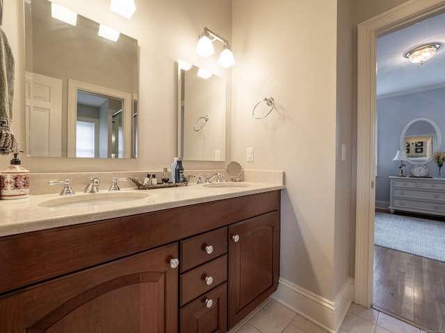 bathroom featuring double vanity, tile patterned flooring, baseboards, and a sink