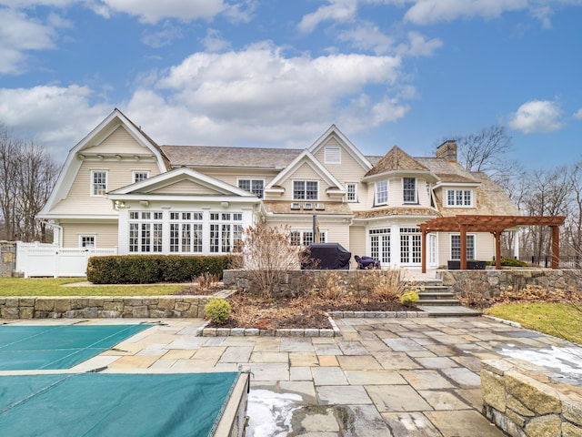 rear view of house with a patio area, fence, a pergola, and a gambrel roof