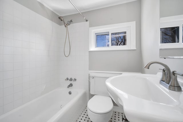 bathroom featuring toilet, shower / bathing tub combination, and a sink