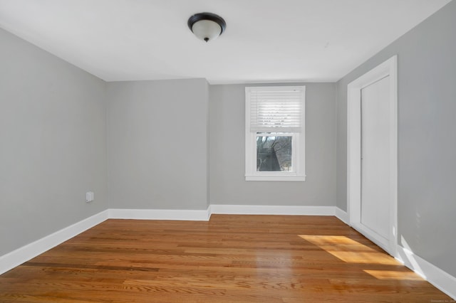 empty room featuring baseboards and wood finished floors