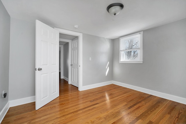 unfurnished room featuring baseboards and light wood-style flooring