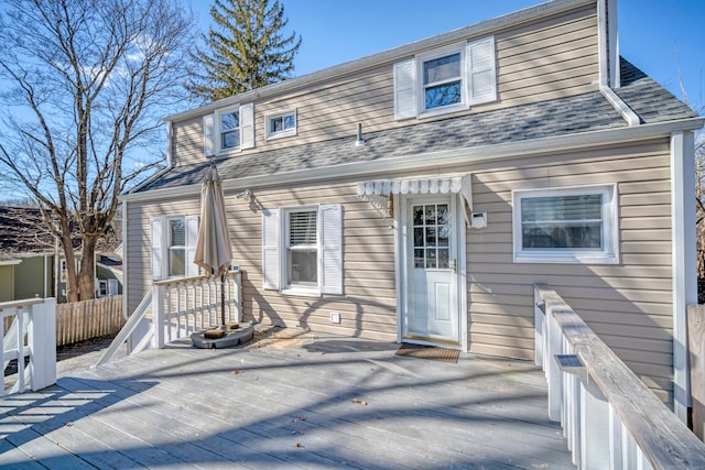 view of front of home featuring a deck and a shingled roof