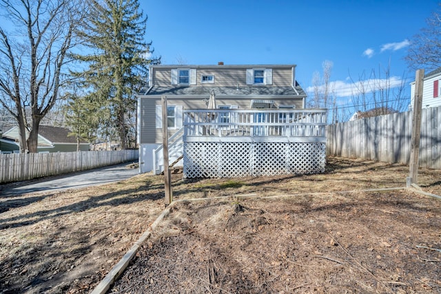 rear view of house featuring fence private yard and a deck