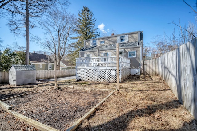 rear view of house with a shed, a fenced backyard, a chimney, an outdoor structure, and a deck