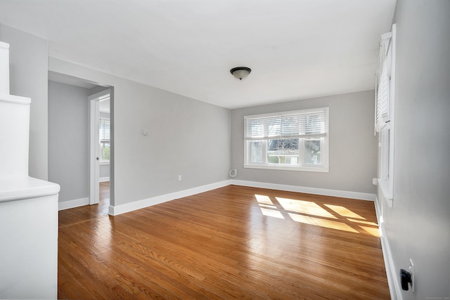 unfurnished room with baseboards and wood finished floors