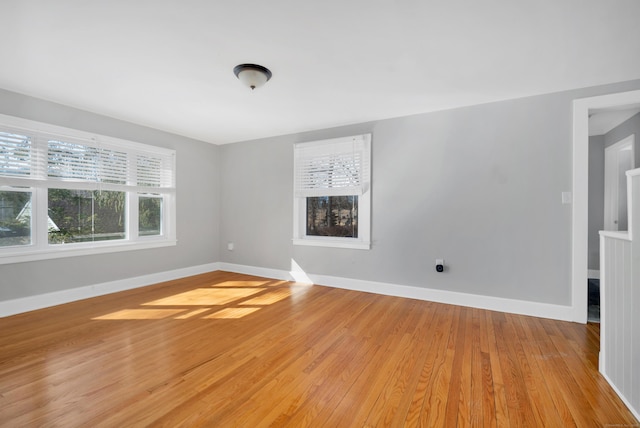 empty room with baseboards and light wood-style flooring