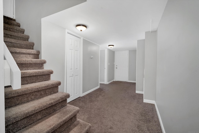 corridor with baseboards, carpet floors, and stairs