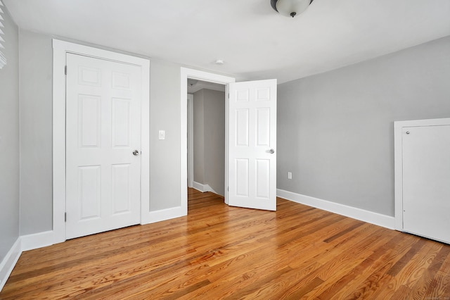 unfurnished bedroom with light wood-type flooring and baseboards