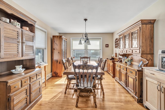 dining room featuring baseboard heating and light wood finished floors