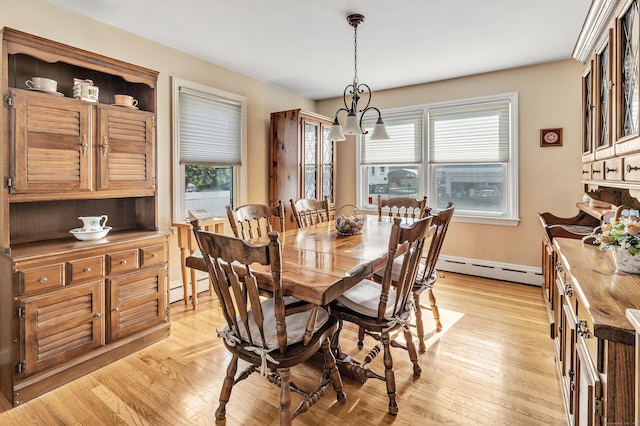 dining space featuring a baseboard heating unit, a baseboard radiator, a notable chandelier, and light wood-style flooring