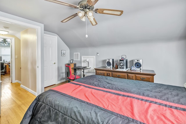 bedroom with lofted ceiling, visible vents, a ceiling fan, baseboards, and light wood finished floors