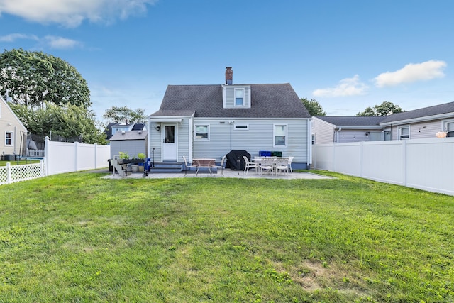 back of house with entry steps, a fenced backyard, a lawn, and a patio