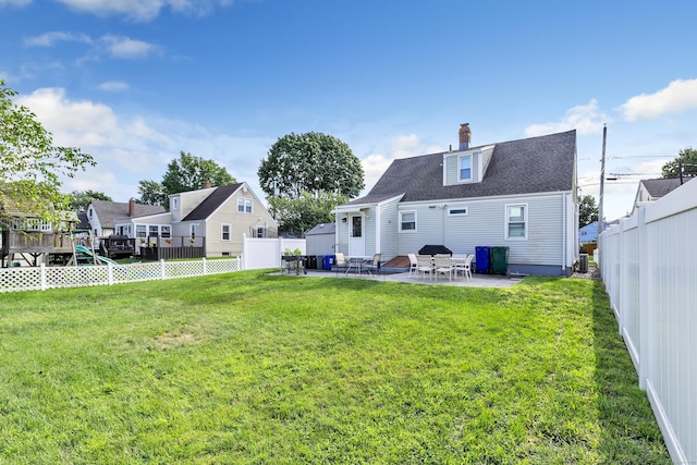 back of property with a fenced backyard, a patio, and a lawn