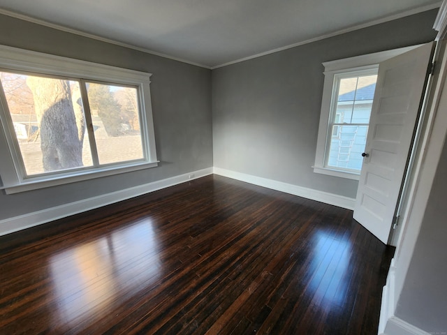 unfurnished room featuring baseboards, dark wood finished floors, and crown molding