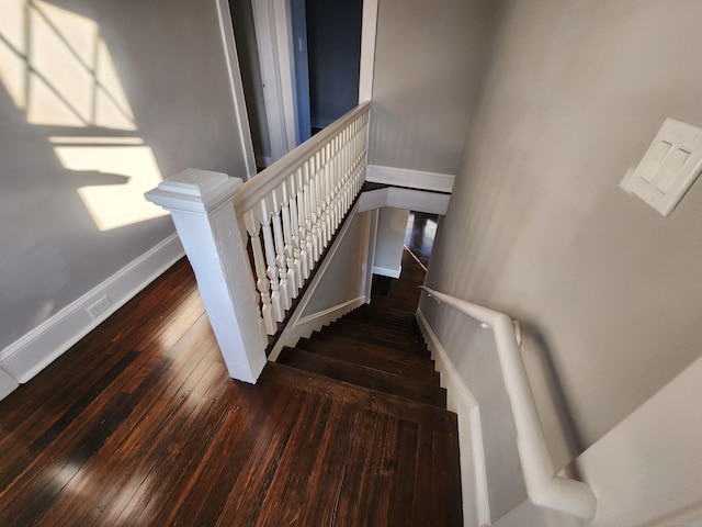 stairway with wood-type flooring and baseboards