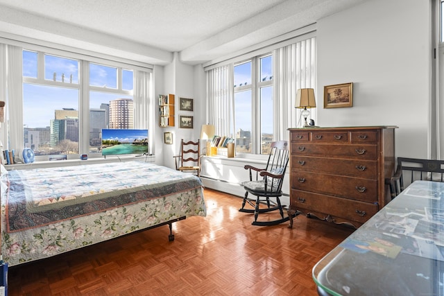 bedroom with a baseboard heating unit and a textured ceiling