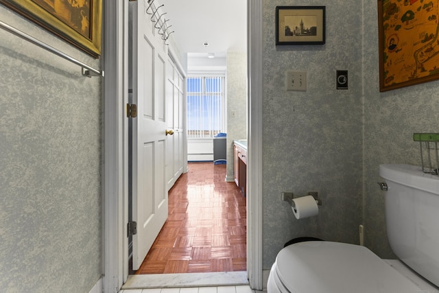 bathroom featuring vanity, toilet, and wallpapered walls