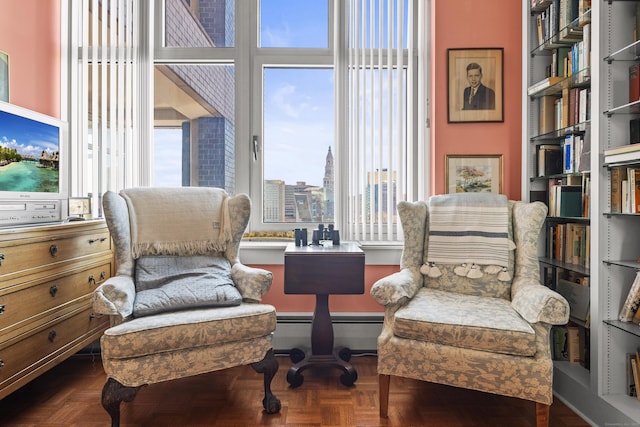 living area featuring a baseboard heating unit and a view of city