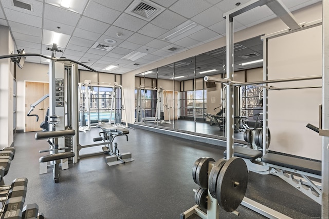 gym with a paneled ceiling and visible vents