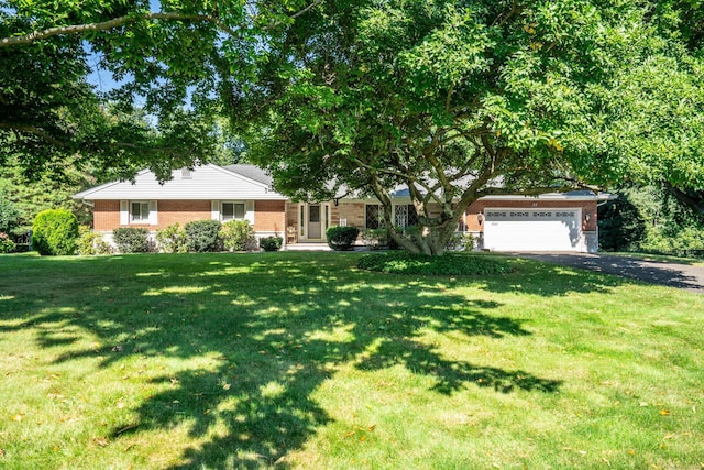 ranch-style home with an attached garage, brick siding, driveway, and a front lawn