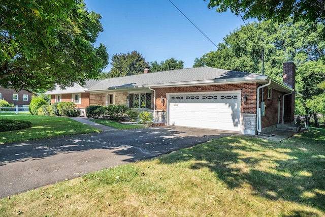 ranch-style home with aphalt driveway, a front yard, a chimney, and an attached garage