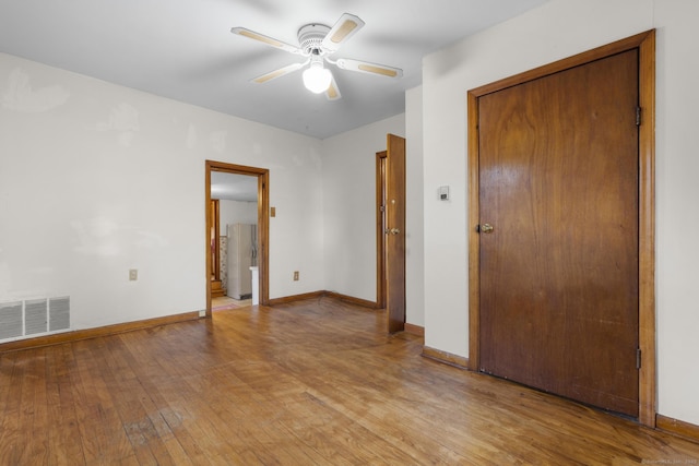 empty room with visible vents, ceiling fan, light wood-style flooring, and baseboards