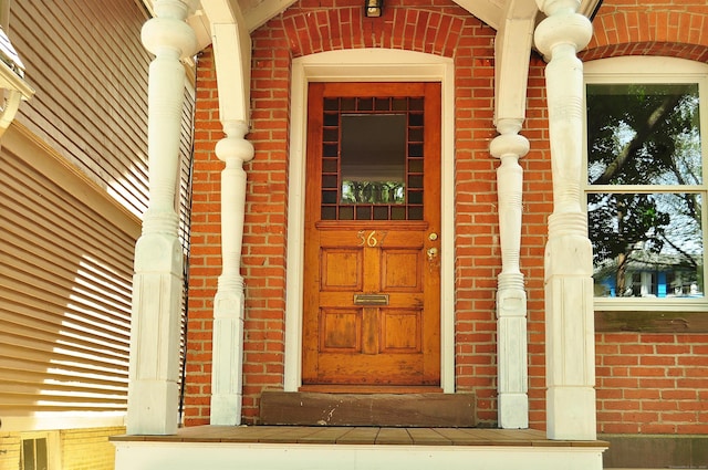 entrance to property featuring brick siding