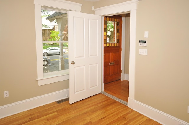 interior space with light wood finished floors, visible vents, and baseboards