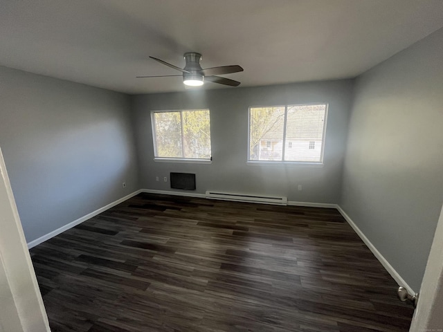 unfurnished room with a baseboard heating unit, ceiling fan, dark wood-style flooring, and baseboards