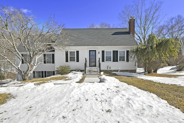 view of front of property featuring a shingled roof and a chimney