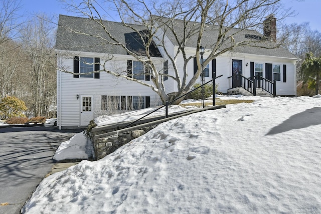 view of front of home featuring roof with shingles and a chimney