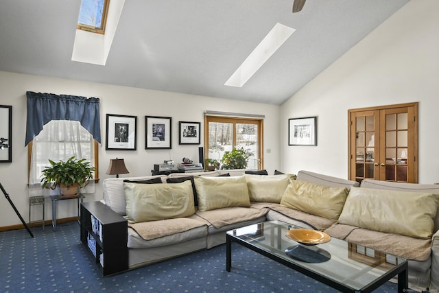 carpeted living area with lofted ceiling with skylight and baseboards