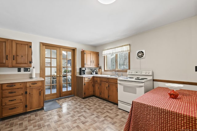 kitchen featuring electric stove, brown cabinets, french doors, light countertops, and visible vents