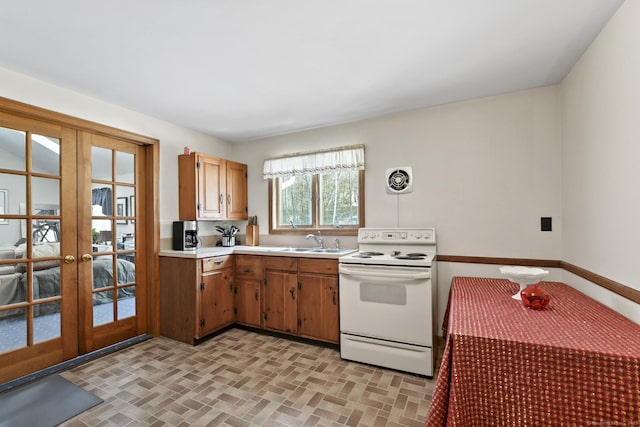 kitchen with white electric range, french doors, a sink, and light countertops