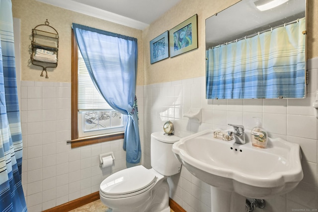 bathroom featuring a shower with shower curtain, a sink, tile walls, and toilet