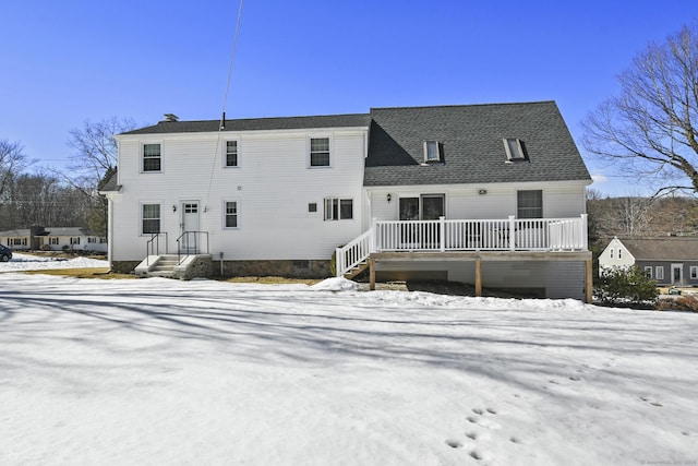 snow covered property featuring roof with shingles