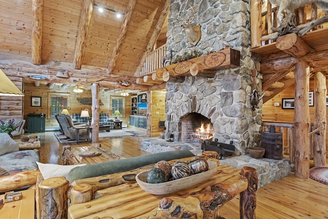 living room featuring wooden ceiling, beamed ceiling, hardwood / wood-style flooring, and a stone fireplace