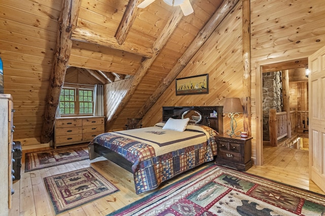 bedroom featuring lofted ceiling with beams, ceiling fan, wood walls, wooden ceiling, and hardwood / wood-style flooring