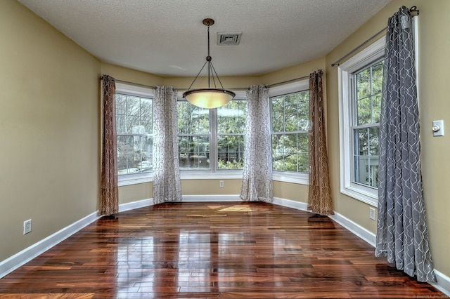75 Redwood Dr Unit 510, East Haven, CT 06513 - unfurnished dining area with a textured ceiling, wood-type flooring, visible vents, and baseboards