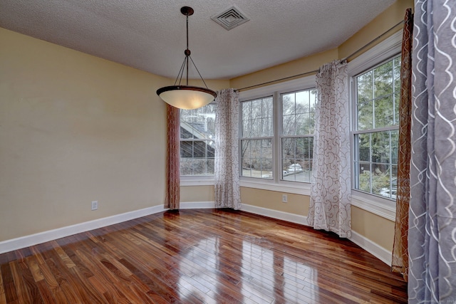 75 Redwood Dr Unit 510, East Haven, CT 06513 - unfurnished dining area featuring baseboards, visible vents, a textured ceiling, and hardwood / wood-style floors