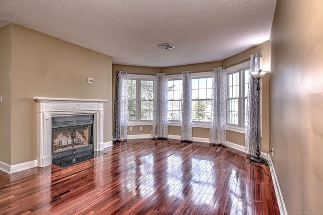 75 Redwood Dr Unit 510, East Haven, CT 06513 - unfurnished living room featuring baseboards, visible vents, a fireplace with flush hearth, hardwood / wood-style floors, and a textured ceiling