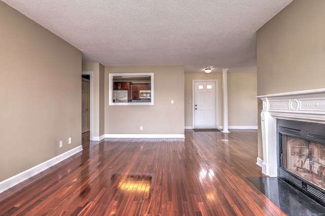 75 Redwood Dr Unit 510, East Haven, CT 06513 - unfurnished living room with baseboards, a fireplace, decorative columns, and hardwood / wood-style floors