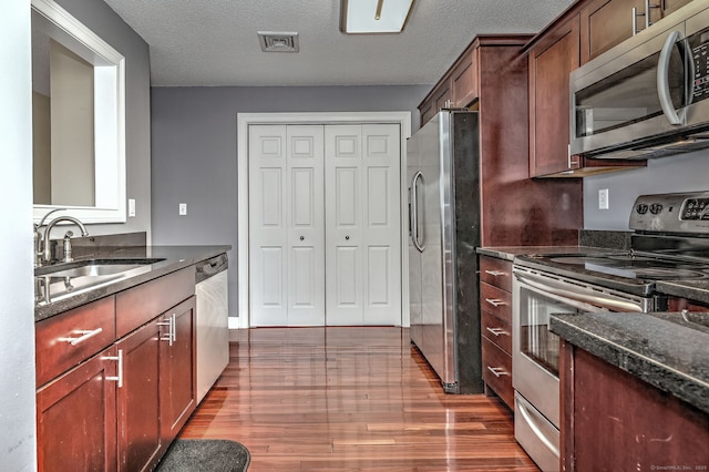 75 Redwood Dr Unit 510, East Haven, CT 06513 - kitchen featuring appliances with stainless steel finishes, dark stone counters, a sink, and wood finished floors