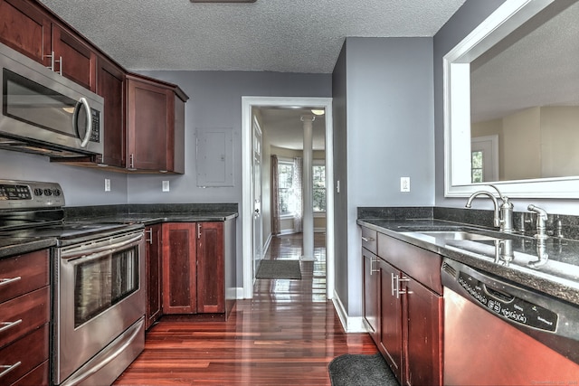 75 Redwood Dr Unit 510, East Haven, CT 06513 - kitchen featuring a textured ceiling, dark stone counters, a sink, appliances with stainless steel finishes, and dark wood-style floors